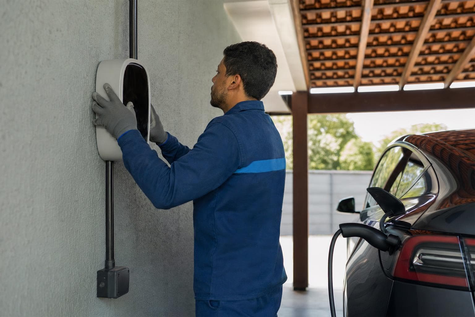 Eletricista instalando um carregador de parede para carro elétrico em uma garagem