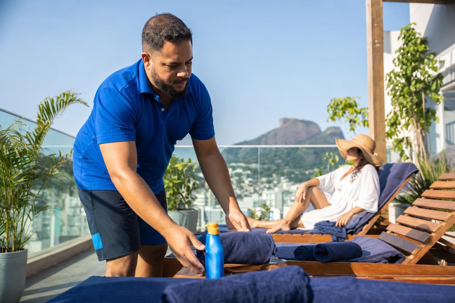 Profissional passando loção em uma cliente na laje de bronzeamento sob o sol