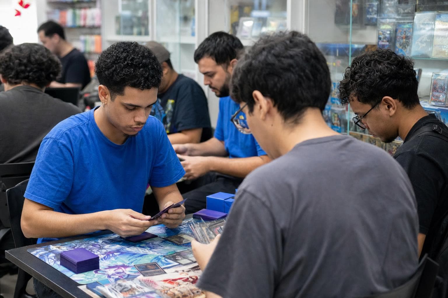 Jogadores disputando uma partida de card game em mesas de uma loja especializada