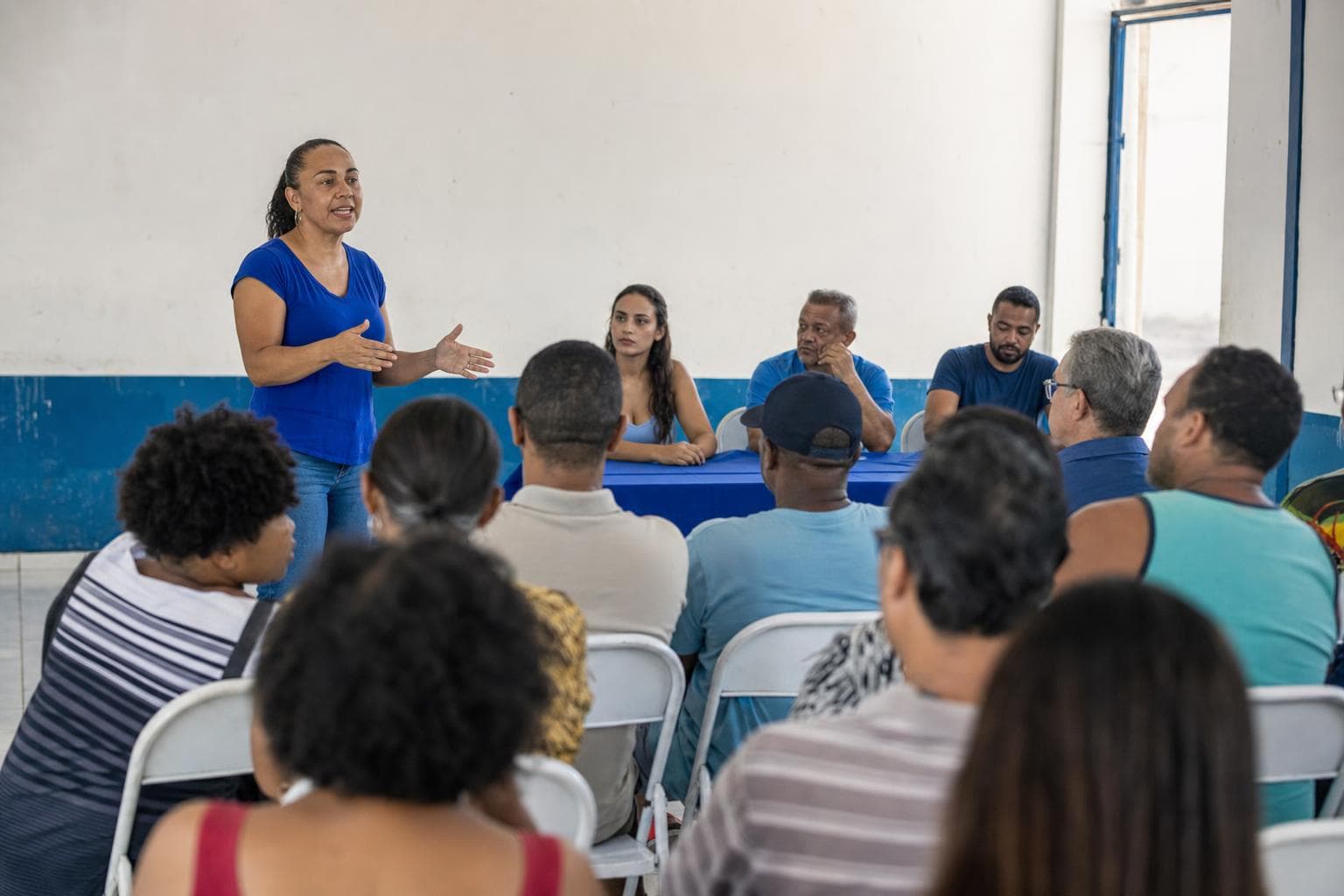 Moradores reunidos em assembleia no salão comunitário do bairro