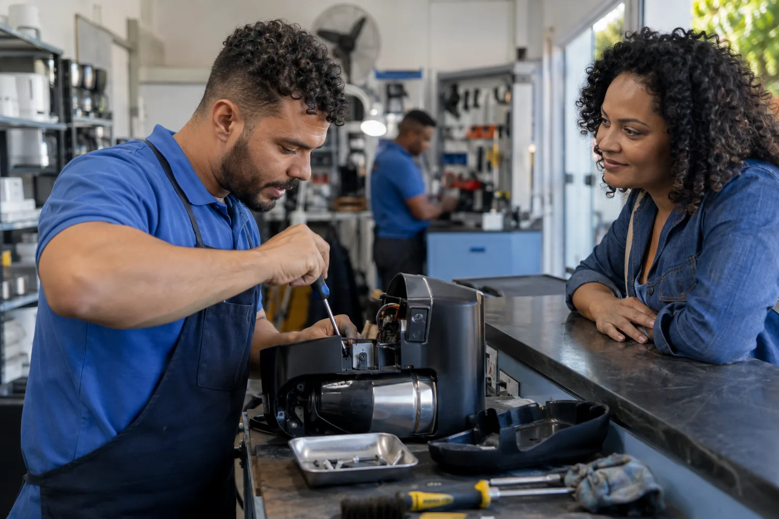 Técnico de assistência autorizada troca a peça defeituosa de um eletrodoméstico na bancada