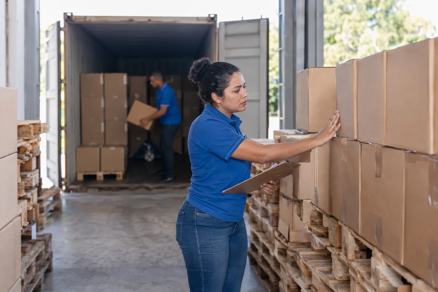 Funcionário de importadora confere caixas recém-chegadas de contêiner no depósito
